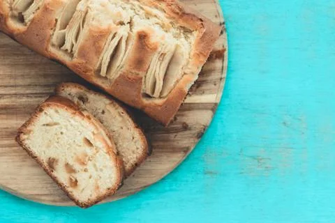Apple sponge cake cut on a kitchen table on a blue background. Copy space. Ba Stock Photos