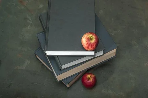 Apple on stack of book on green wood table study. Stock Photos