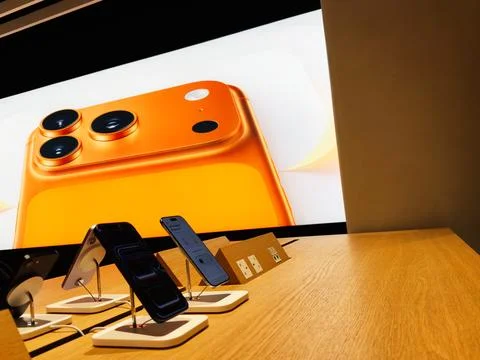Apple store display of orange iPhone 17 Pro devices with large screen backd.. Stock Photos