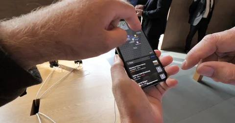 Apple Store with senior man compare iPhone Xs and Maps Vidéo 95587695