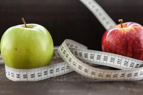 An Apple surrounded by a measuring tape tailor on wood Stock Photos