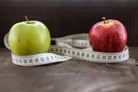 An Apple surrounded by a measuring tape tailor on wood Stock Photos