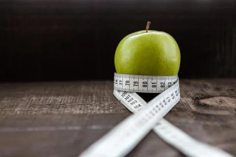 An Apple surrounded by a measuring tape tailor on wood Stock Photos