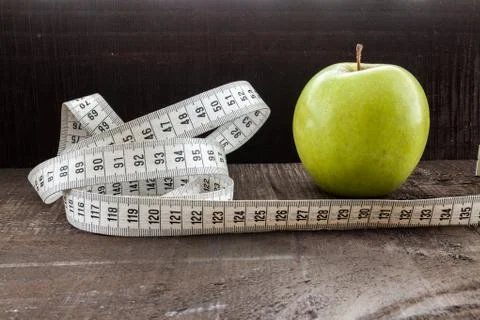 An Apple surrounded by a measuring tape tailor on wood Stock Photos