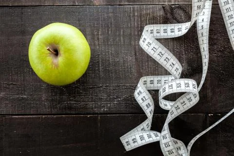 An Apple surrounded by a measuring tape tailor on wood Stock Photos