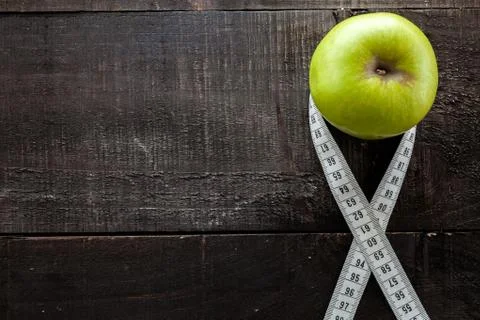 An Apple surrounded by a measuring tape tailor on wood Stock Photos