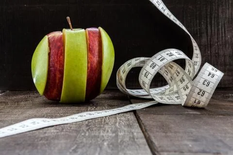 An Apple surrounded by a measuring tape tailor on wood Stock Photos