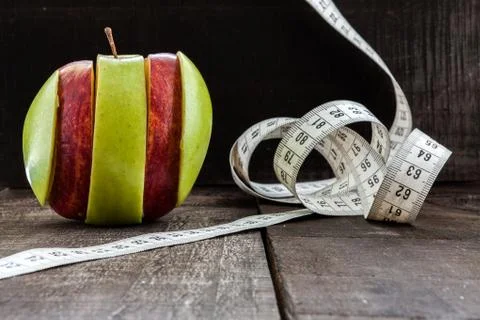An Apple surrounded by a measuring tape tailor on wood Stock Photos