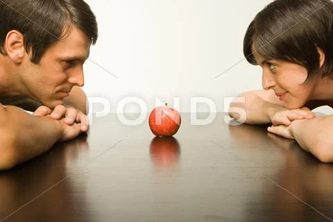 Apple on table between couple Stock Photos