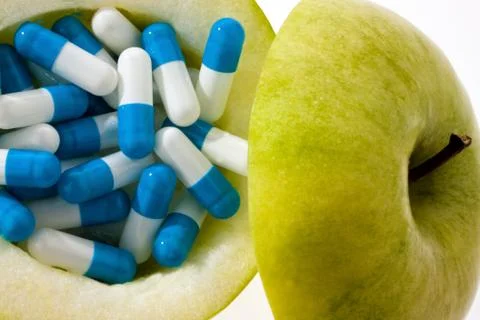 Apple with tablets capsules. Stock Photos