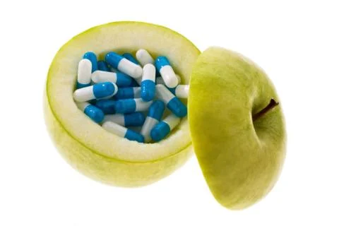 Apple with tablets capsules. Stock Photos