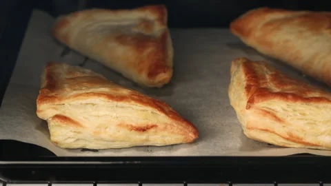 Apple turnovers with puff pastry baking in the oven time lapse Stock Footage 242530580