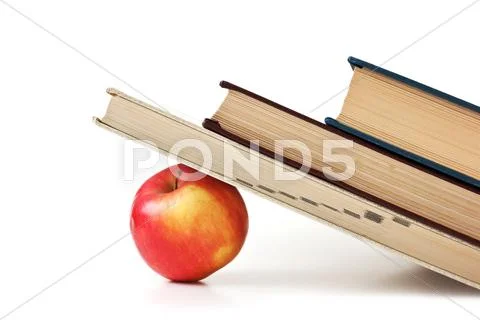 Apple under a pile of books Stock Photos