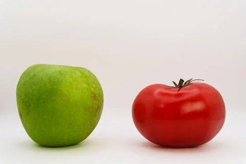 Apple vs tomato on white background, vegetables vs fruits, healthy eating Stock Photos