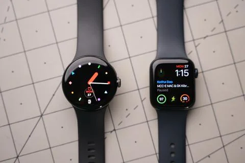 An apple Watch and a Google Pixel Watch on top of a table Stock Photos
