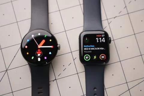 An apple Watch and a Google Pixel Watch on top of a table Stock Photos