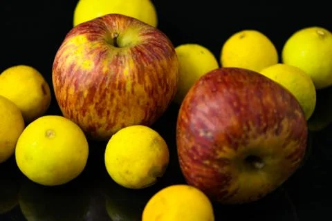 Apples and lemons on black background Stock Photos