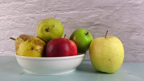 Apples and pears in a bowl on a table with pan dolly camera movement Stock Footage 330687190