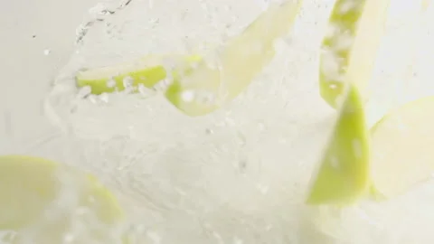 Apples and Slices Falling on White Background with Water Stock Footage 147345494