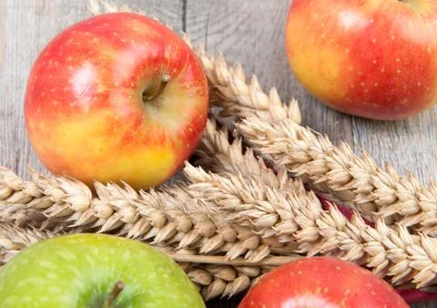 Apples and wheat cobs placed on a wooden table Stock Photos