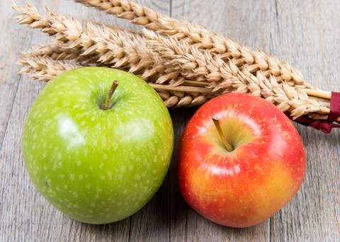 Apples and wheat cobs placed on a wooden table Stock Photos