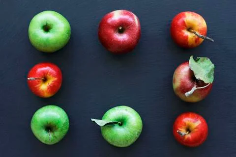 Apples on dark background, frame from ripe apples. Green and red apples Stock Photos