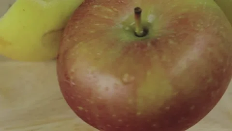 Apples with drops of water rotate on a natural wooden background Stock Footage 131074853
