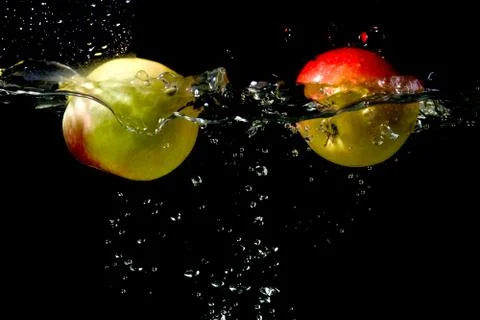 Apples falling to the water Stock Photos