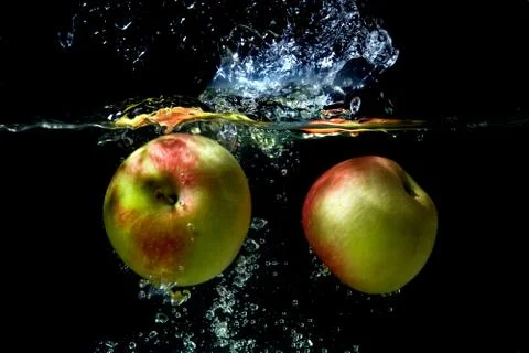 Apples falling to the water Stock Photos