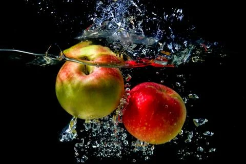 Apples falling to the water Stock Photos