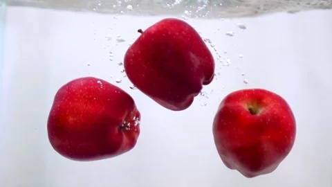 Apples falls in water in slow motion Stock Footage