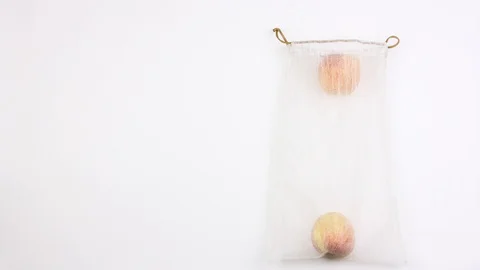 Apples one by one fill reusable recycled mesh grocery bag, zero waste shopping 動画素材 111211174