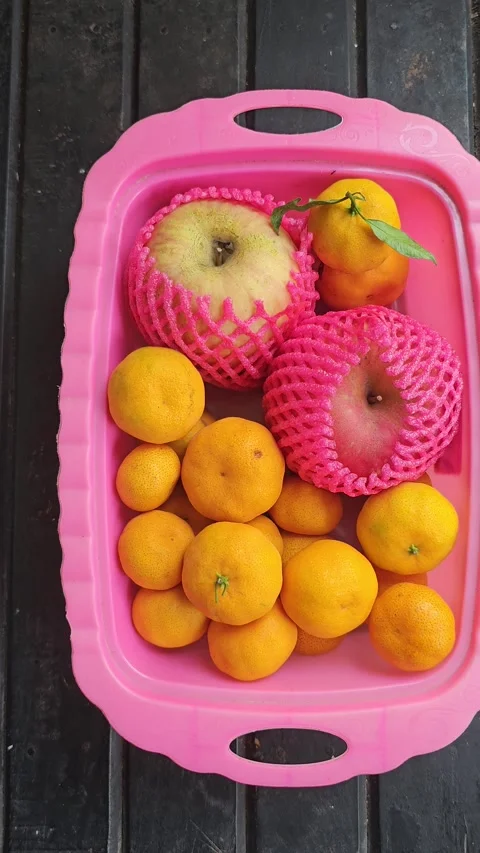 Apples in Protective Nets and Mandarin Oranges in Pink Tray Stock Footage 332027915