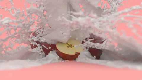 Apples on a red background in a splash of milk Stock Footage 154218485