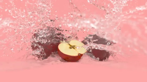 Apples on a red background in splashes of water Stock Footage 154218481