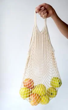 Apples in a string bag in hand. Natural fresh organic fruits. food diet. Stock Photos