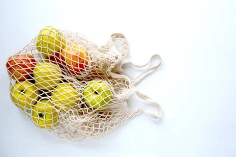 Apples in a string bag. Natural fresh organic fruits. Healthy food. Stock Photos