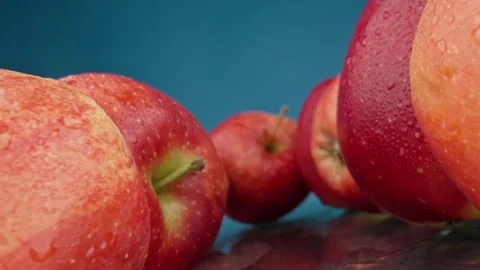 Apples with water drops. Camera moving and rotating through a row of red apples Video stock 243608372