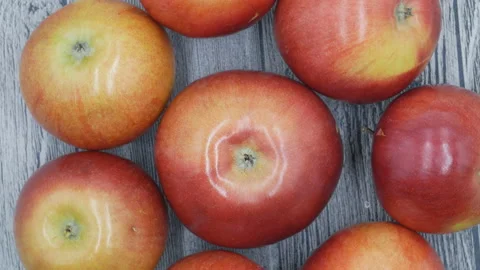 Apples on a wooden table. Camera slowly turns around the fruit. Stock Footage 106721977