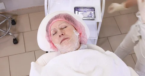 Application of anesthetic cream process to the senior woman Stock Footage 102028255