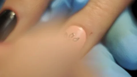 Application of black design on the pink nails of the client in the office for Video stock 126171189