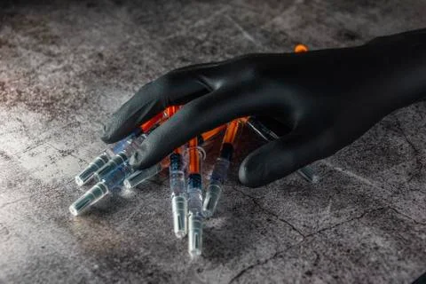 Application of botox in pre-filled syringe in hand with black latex gloves Stock Photos