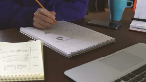 The application developer draws sketches in a notebook. Works remotely from home Video stock 88172744