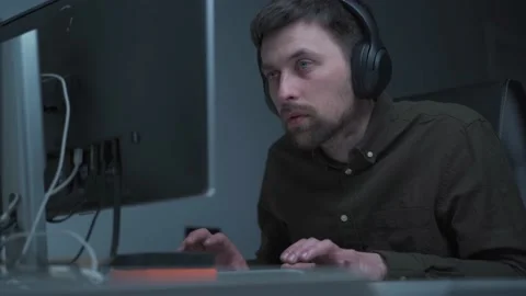 Application developer in wireless headphones working. sitting at computer Stock Footage 162482588