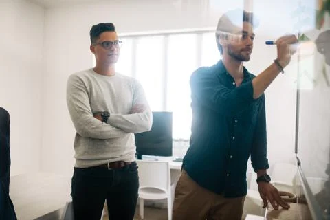 Application developer writing on board in office Stock Photos