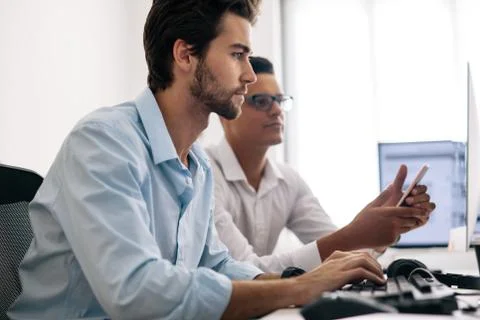 Application developers working on computers in office Stock Photos