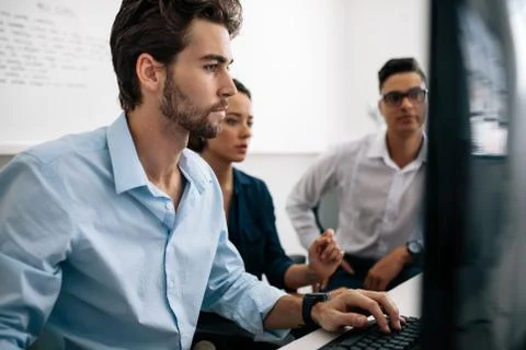 Application developers working on computers in office Stock Photos