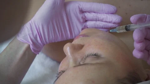 Application of oil on face. Girl does anti-aging facial skin massage in a luxury Video stock 120577664