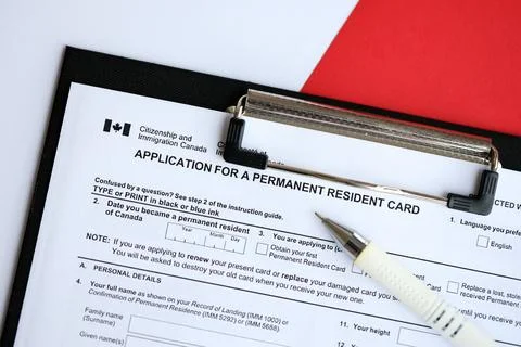 Application for permanent resident card on table with pen Stock Photos