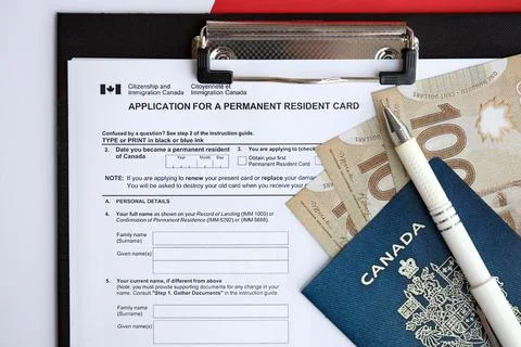 Application for permanent resident card on table with pen and canadian passport Stock Photos
